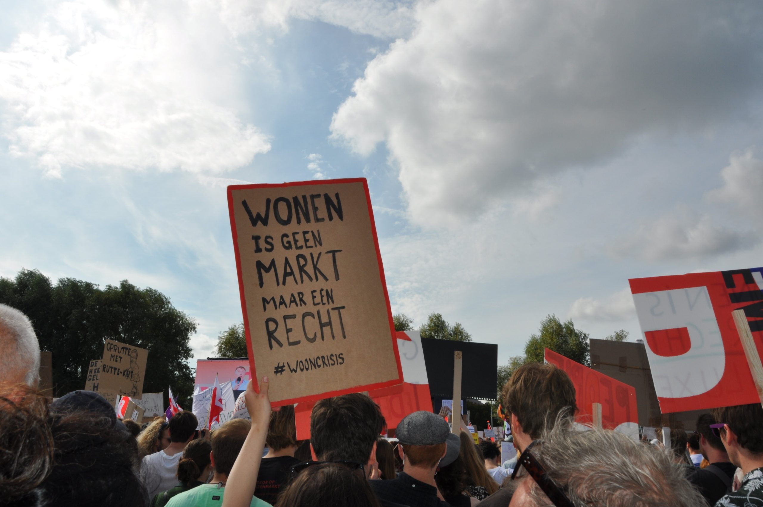 Protest actie, met bordje waarop staat "wonen is geen markt maar een recht".